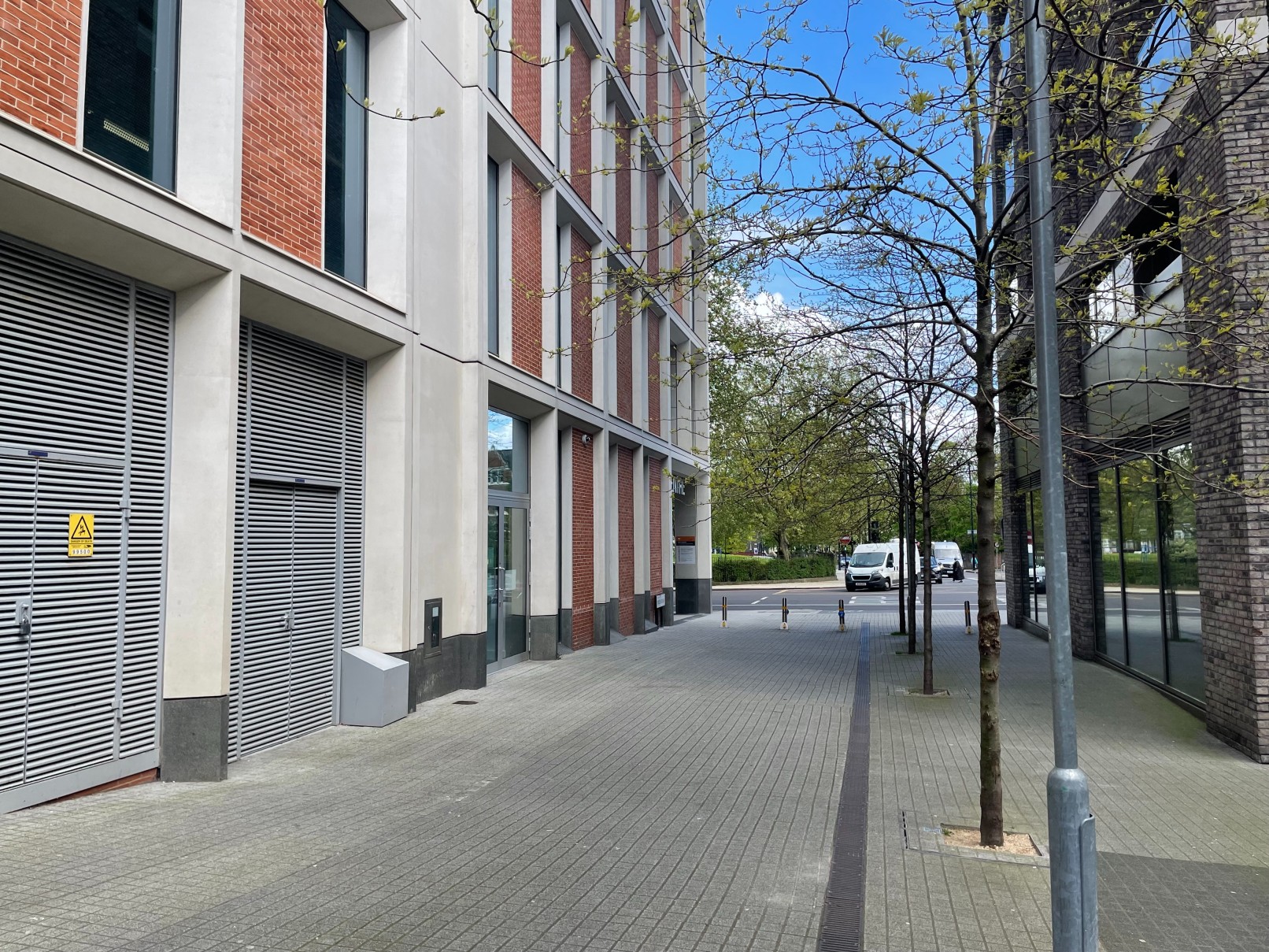 Tree-lined sidewalk next to modern buildings on Porden Street.