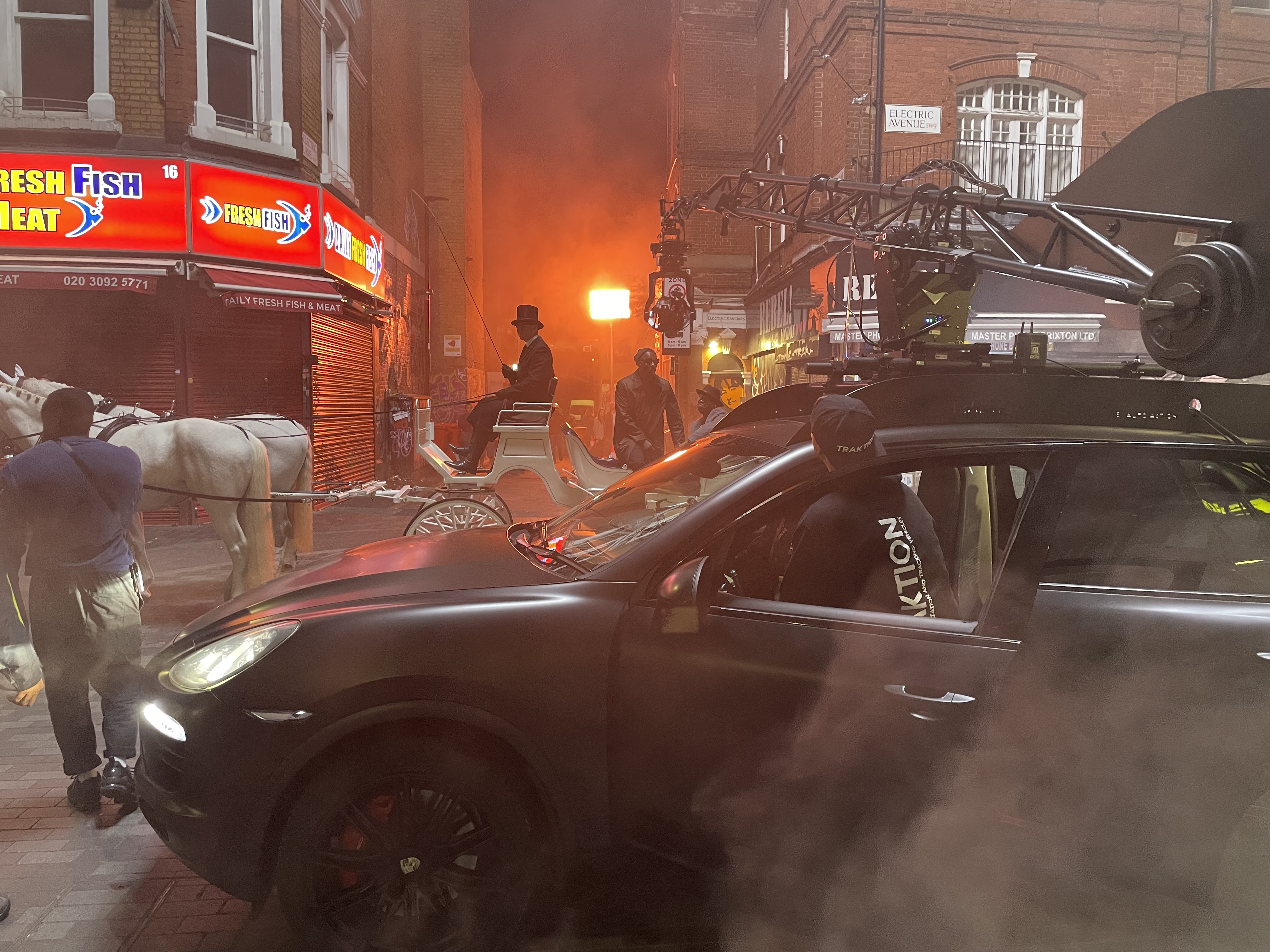 2 white horses and a carriage. A car with a camera mounted to the roof.