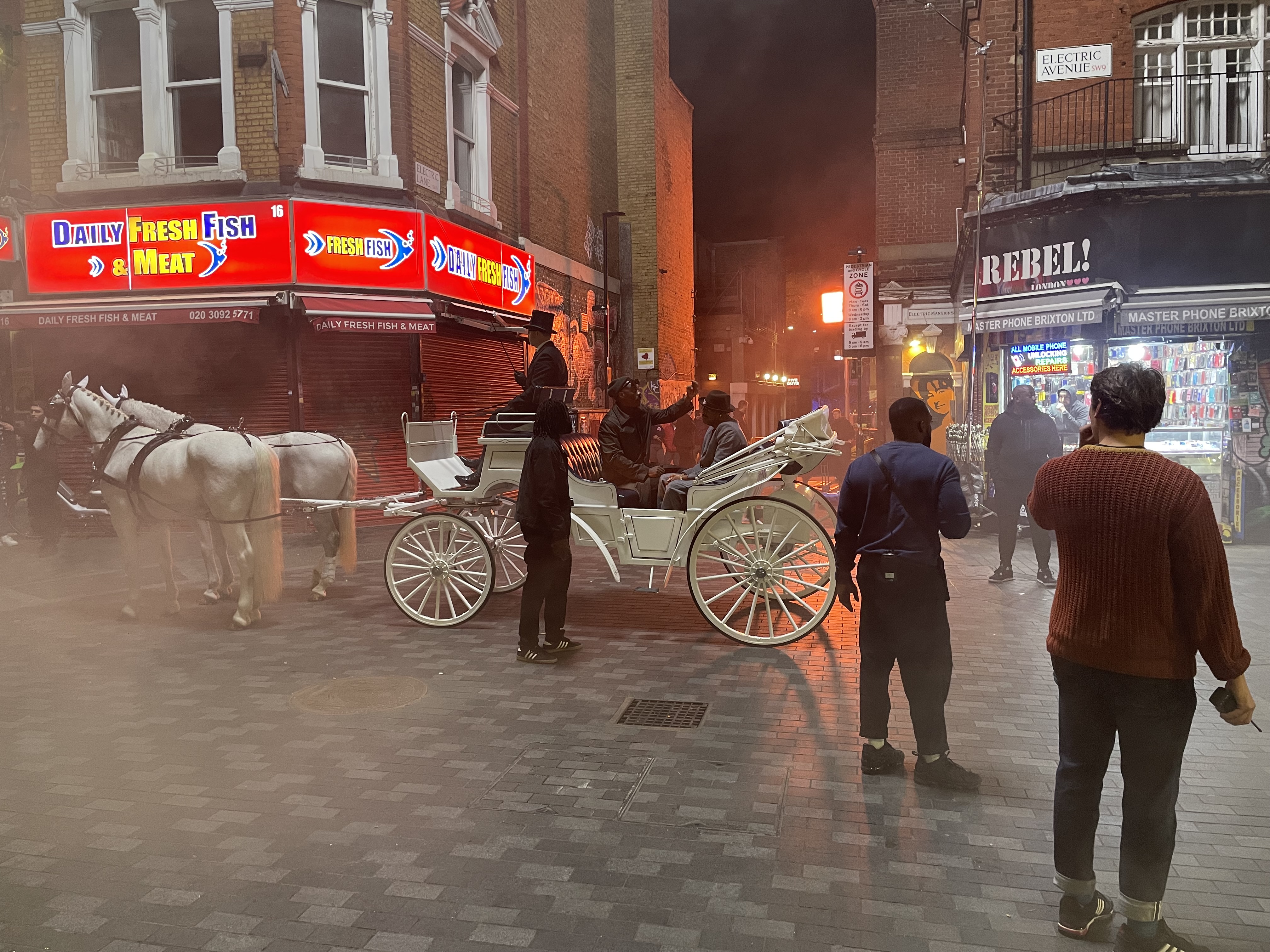 white horses and a carriage along Electric Avenue