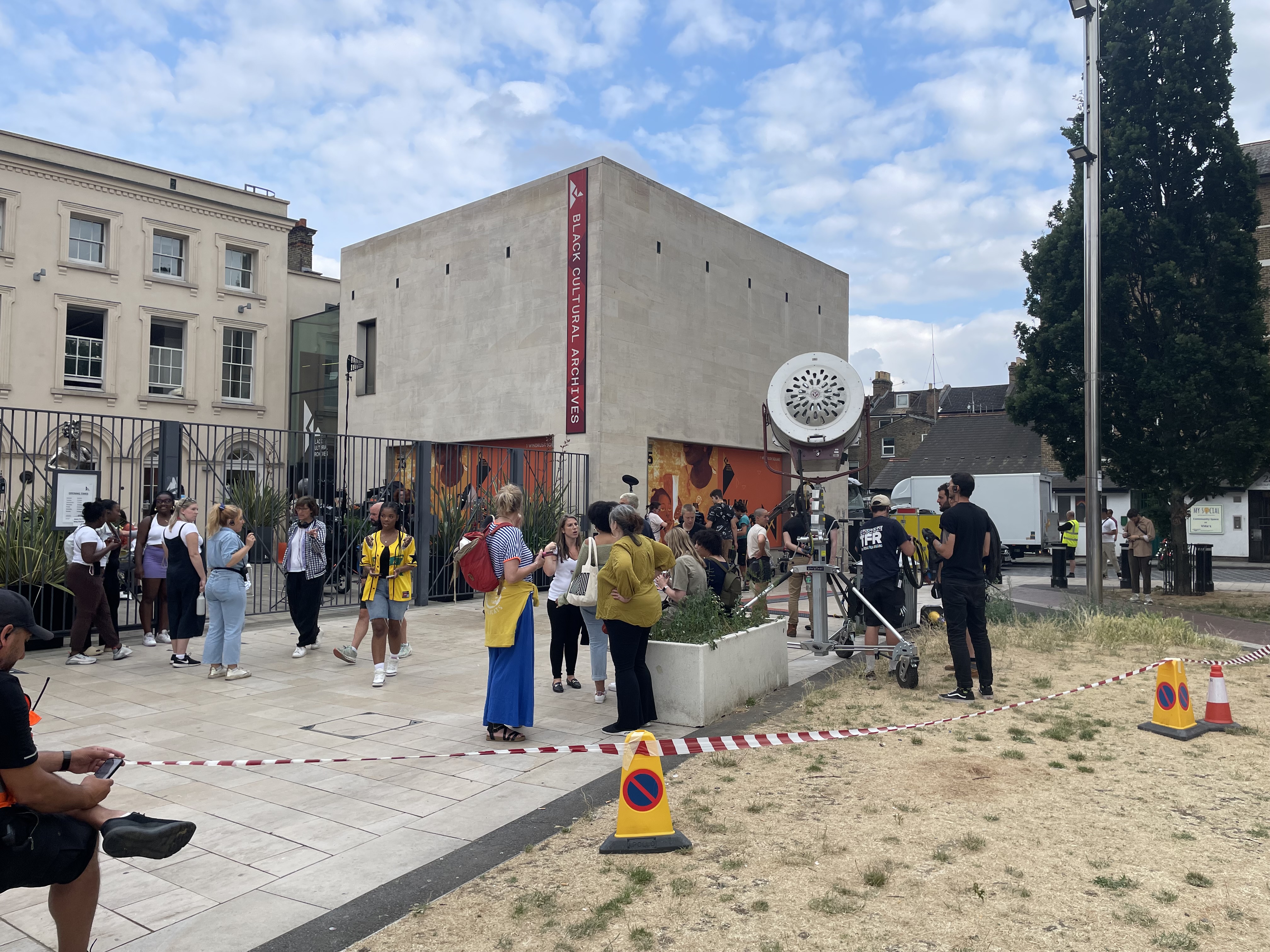 pan shot of Windrush square where the cast and crew are mingling outside the Black Cultural Archives