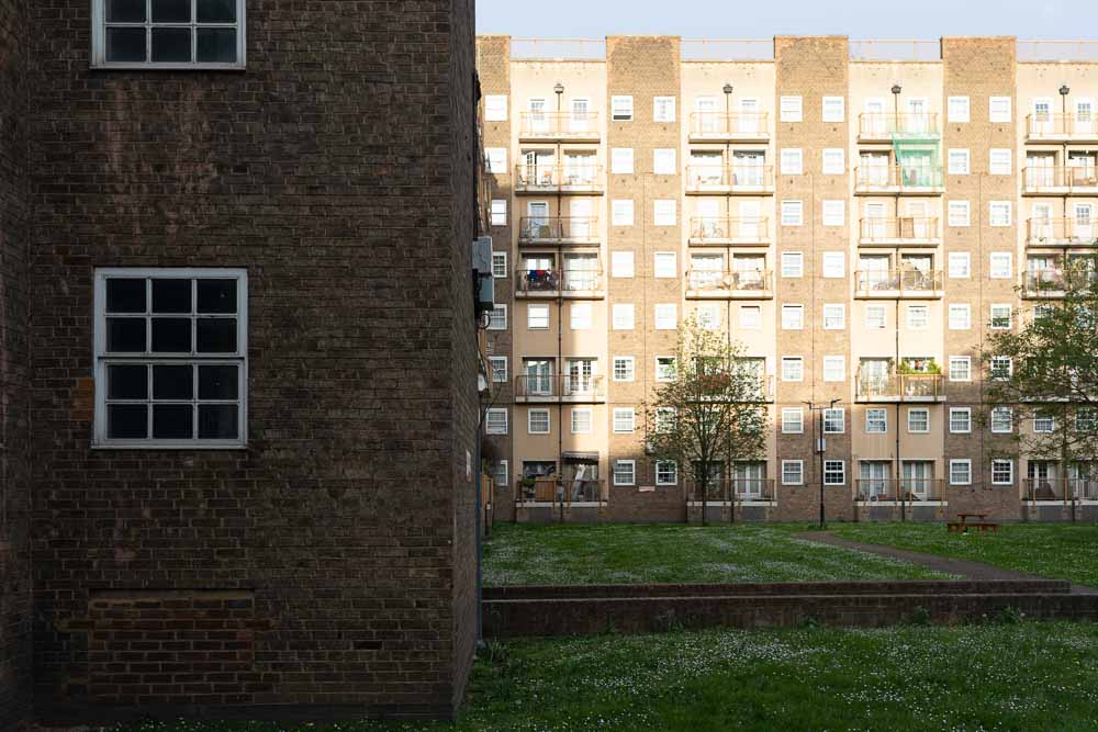 Exterior view of Notre Dame Estate buildings in Lambeth with grass courtyard.